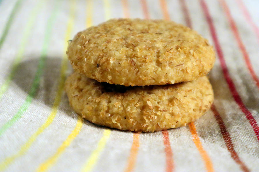 Two Stacked Spicebush Berry Honey Cookies on a Rainbow Tea Towel