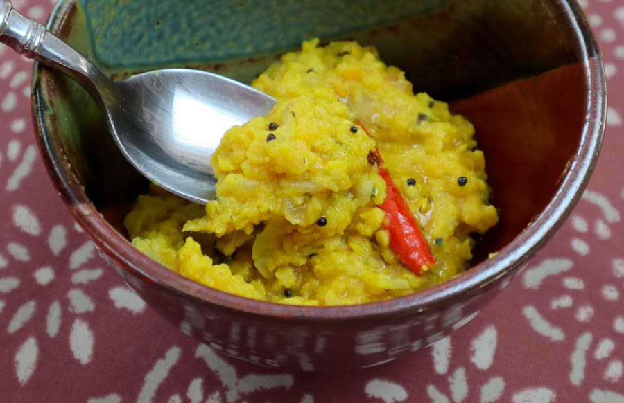 Spicebush berry dal with chile pepper and spoon